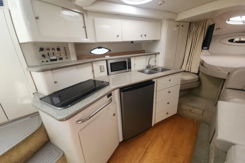 Slide: The Image of Interior of 2000 Maxum 3300 SCR yacht featuring kitchenette with sink, stove, and microwave. - 6