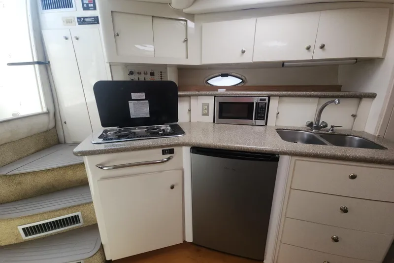 Slide: The Image of Compact kitchen in 2000 Maxum 3300 SCR boat with stove, microwave, and sink. - 8