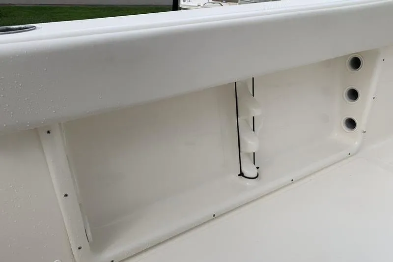 Slide: The Image of 2026 Bulls Bay 255CC boat interior detail with storage compartment and rod holders. - 11