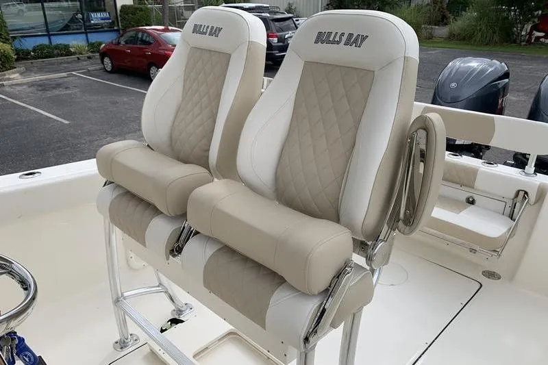 Slide: The Image of 2026 Bulls Bay 255CC boat with beige and white cushioned seats. - 15
