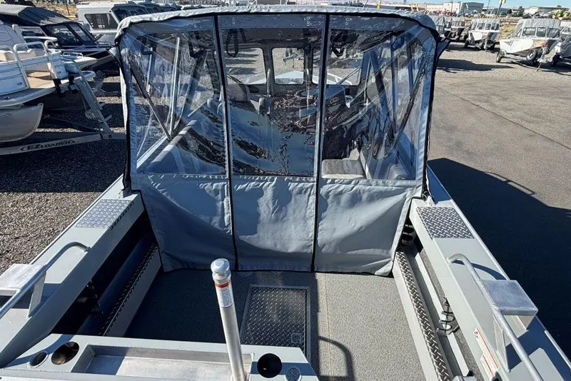 Slide: The Image of 2025 Hewescraft 190 Sea Runner ET boat with protective canopy in a marina setting. - 3