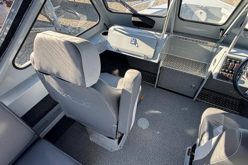 Slide: The Image of Interior of 2025 Hewescraft 190 Sea Runner ET boat, featuring gray seating and control panel. - 6