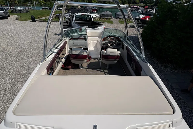 Slide: The Image of 1997 Chaparral 2130 Sport boat interior with seating and steering wheel, parked near marina. - 4