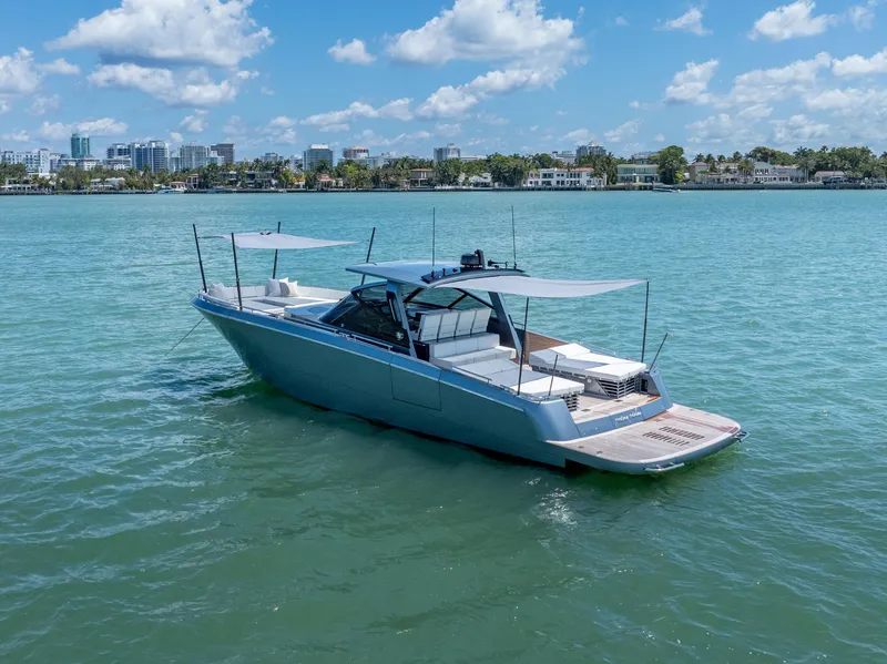 Slide: The Image of 2024 CNM CONTINENTAL 54 SuperSport yacht on calm water, city skyline in background. - 10