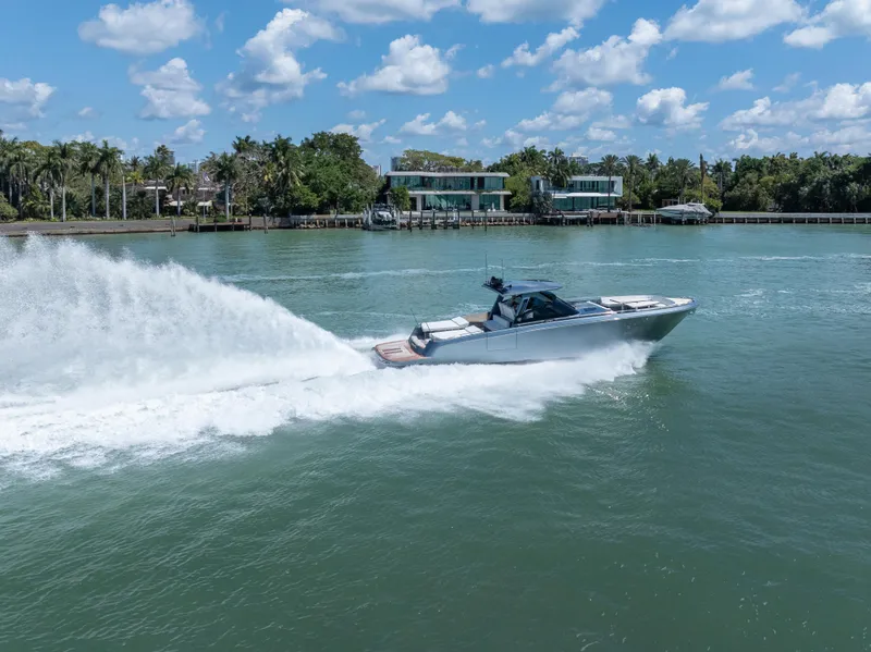 Slide: The Image of 2024 CNM CONTINENTAL 54 SuperSport cruising on a sunny day, surrounded by lush greenery. - 11