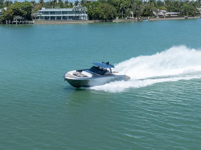 Slide: The Image of 2024 CNM CONTINENTAL 54 SuperSport yacht speeding on a serene waterway. - 16