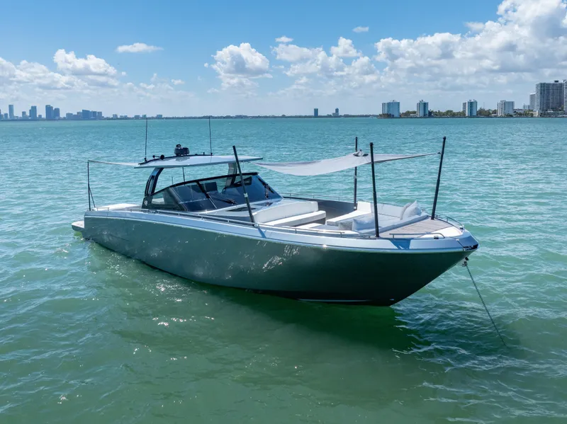 Slide: The Image of 2024 CNM CONTINENTAL 54 SuperSport yacht on calm water, city skyline in background. - 9