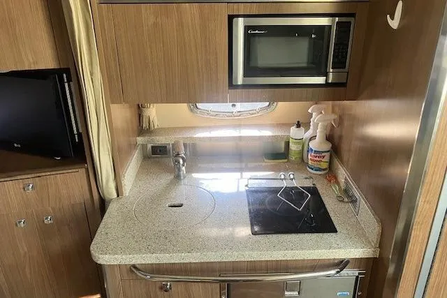 Slide: The Image of 2010 Chaparral Signature 310 boat kitchen with microwave, sink, and stove. - 6