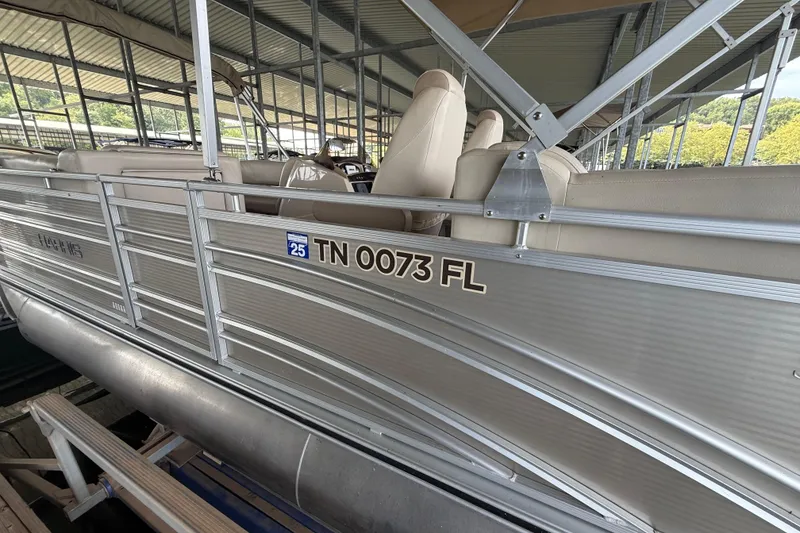 Slide: The Image of 2018 Harris FloteBote Solstice 240 pontoon boat docked, featuring beige seating and registration number TN 0073 FL. - 11
