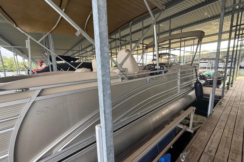 Slide: The Image of 2018 Harris FloteBote Solstice 240 pontoon boat docked under a covered marina. - 4