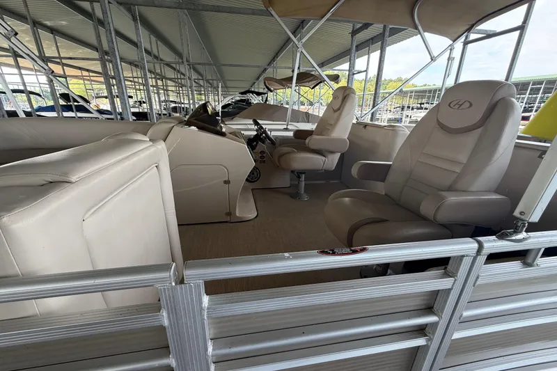Slide: The Image of 2018 Harris FloteBote Solstice 240 pontoon boat interior with beige seating and helm. - 7
