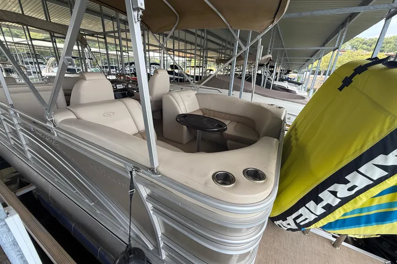 Slide: The Image of 2018 Harris FloteBote Solstice 240 pontoon boat with beige seating and canopy in marina. - 9