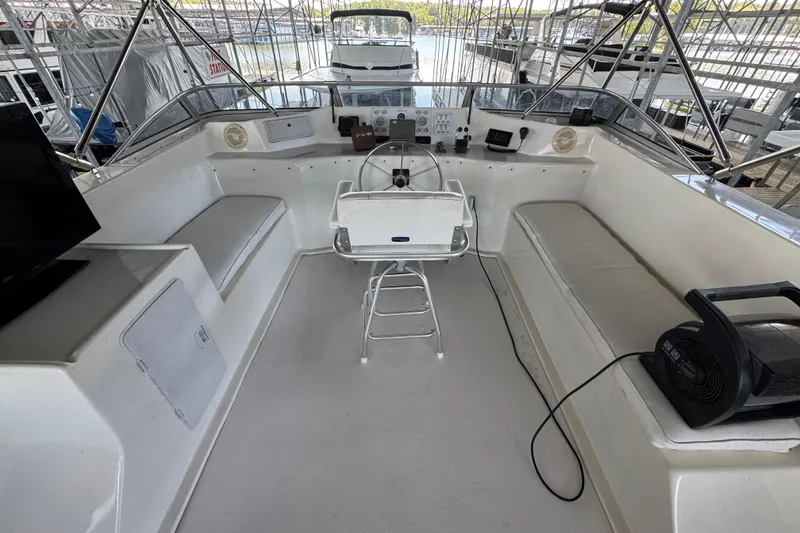 Slide: The Image of 2002 Sumerset Houseboat deck with seating, TV, and canopy on a scenic lake. - 11