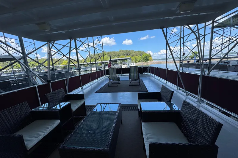 Slide: The Image of 2002 Sumerset Houseboat helm with scenic lake view and maroon canopy. - 12