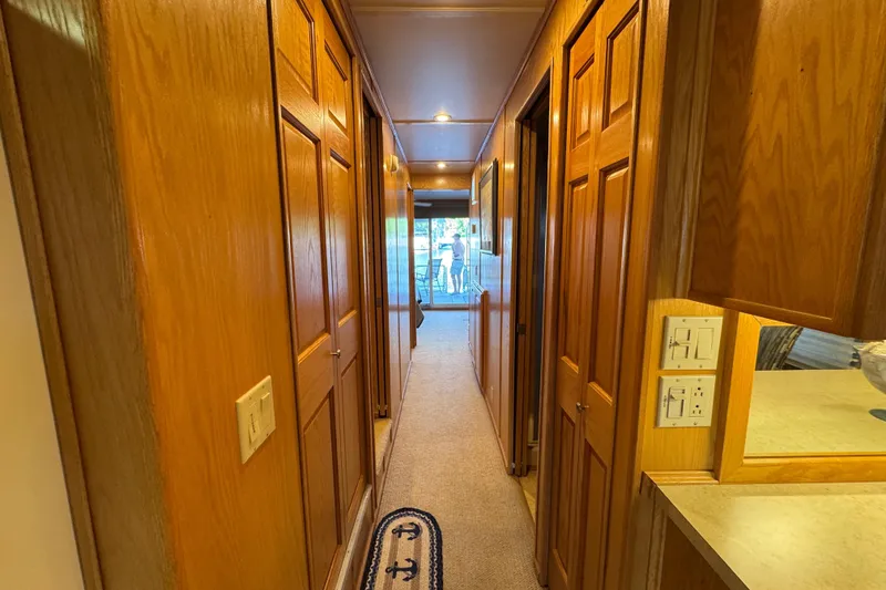 Slide: The Image of 2002 Sumerset Houseboat helm with navigation equipment and steering wheel on a serene waterway. - 16