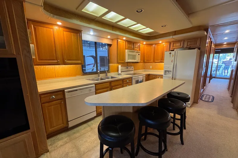 Slide: The Image of 2002 Sumerset Houseboat deck with bar, chairs, and scenic lake view. - 18