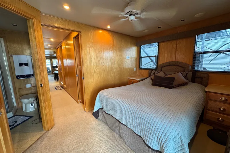 Slide: The Image of 2002 Sumerset houseboat deck with chairs, flags, and scenic lake view. - 23