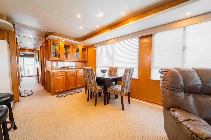 Slide: The Image of Luxurious 2002 Sumerset houseboat interior with dining area, plush seating, and elegant wood cabinetry. - 33