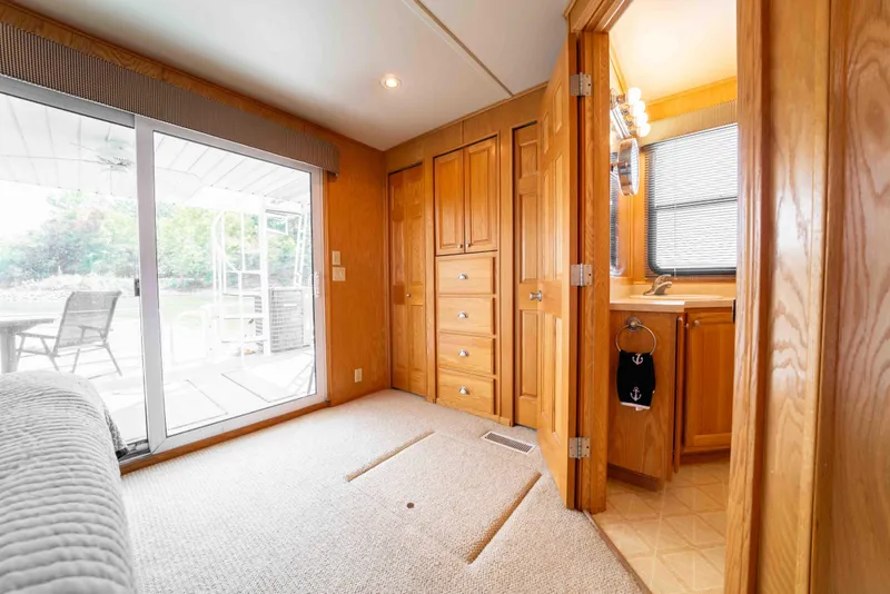 Slide: The Image of Interior of a 2002 Sumerset houseboat with wooden cabinetry and sliding glass door. - 38