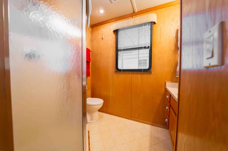 Slide: The Image of Bathroom interior of 2002 Sumerset Houseboat with wooden walls and frosted shower door. - 44
