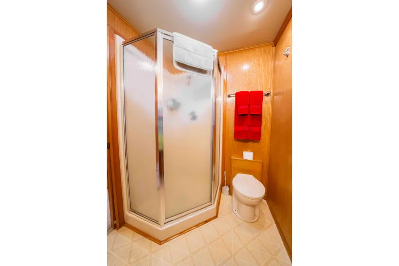 Slide: The Image of Bathroom interior of 2002 Sumerset Houseboat with shower, toilet, and red towels. - 45