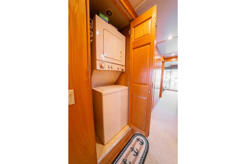 Slide: The Image of 2002 Sumerset Houseboat interior with stacked washer and dryer in wooden cabinet. - 46