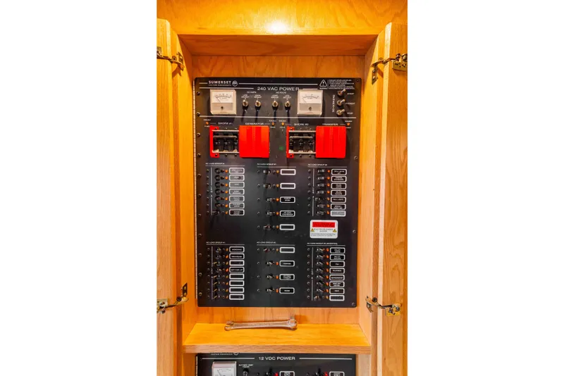 Slide: The Image of Electrical panel inside a 2002 Sumerset houseboat, featuring various switches and meters. - 49