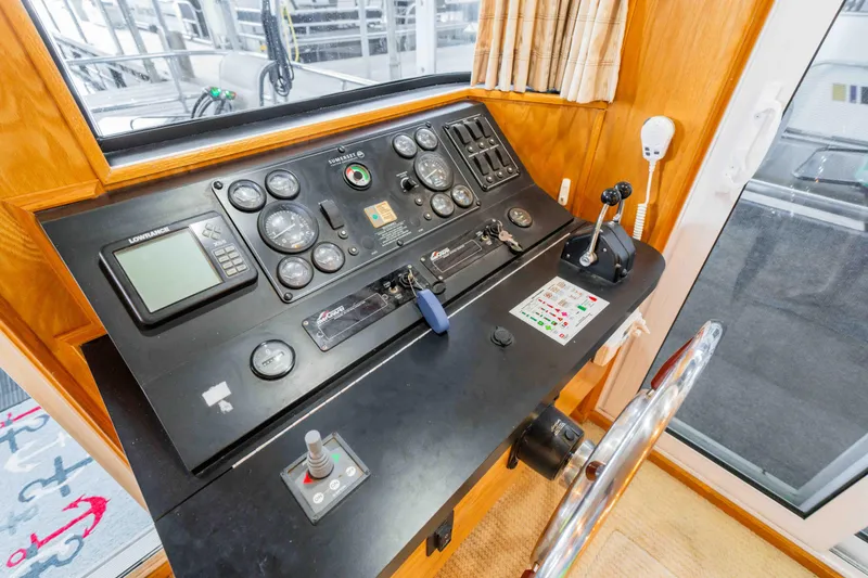 Slide: The Image of Control panel of a 2002 Sumerset Houseboat with navigation instruments and steering wheel. - 51
