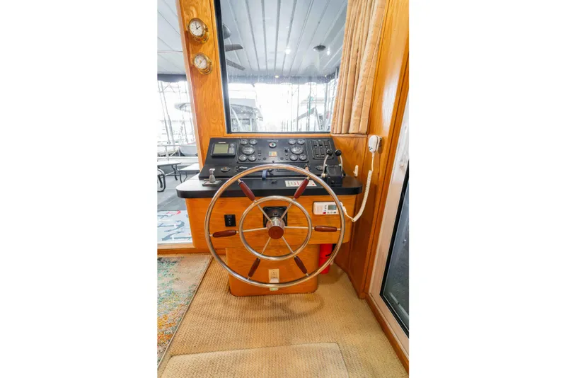 Slide: The Image of 2002 Sumerset Houseboat helm with steering wheel and control panel. - 55