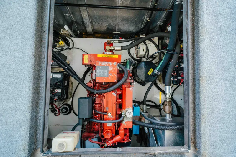 Slide: The Image of Engine compartment of a 2002 Sumerset Houseboat, featuring various mechanical components and hoses. - 56