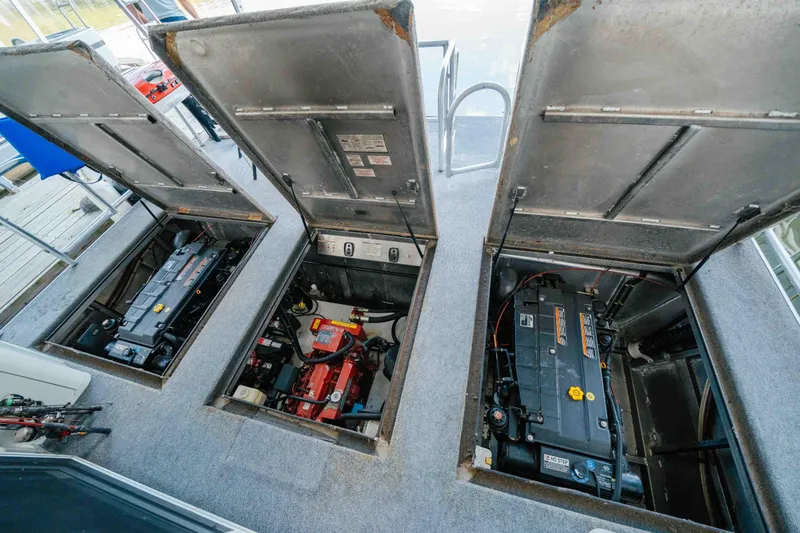 Slide: The Image of Open engine compartments of a 2002 Sumerset houseboat, showcasing mechanical components. - 60