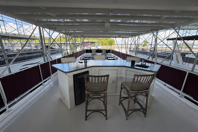 Slide: The Image of 2002 Sumerset houseboat on a serene lake with lush green trees in the background. - 7