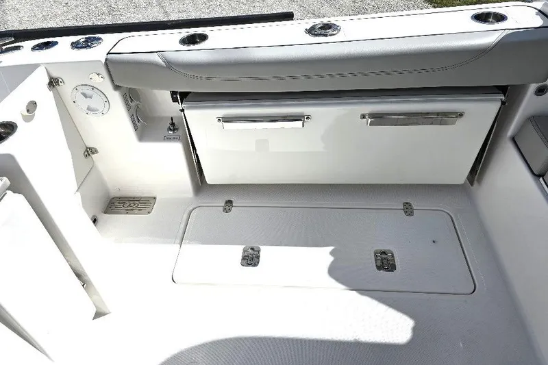 Slide: The Image of 2024 Pursuit DC 326 Dual Console boat interior with storage compartments and seating. - 12