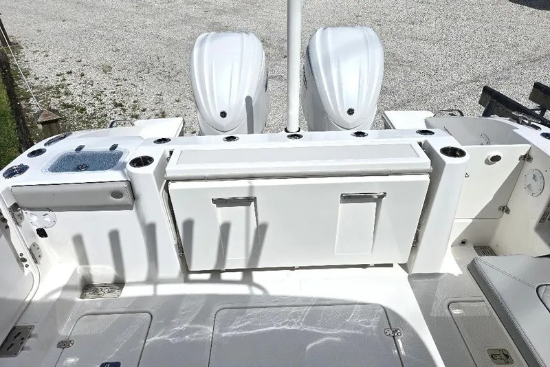 Slide: The Image of 2024 Pursuit DC 326 Dual Console boat deck with twin engines and storage compartments. - 14