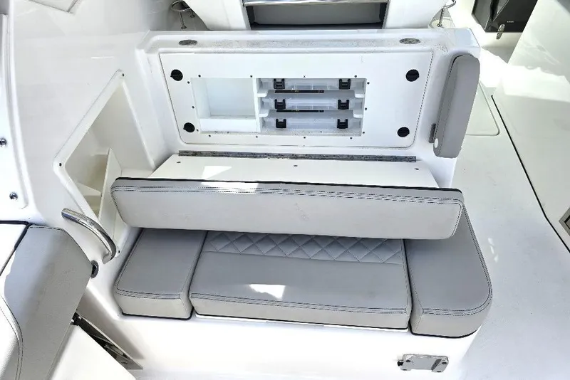 Slide: The Image of 2024 Pursuit DC 326 Dual Console boat seating area with storage compartments. - 18