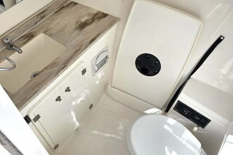 Slide: The Image of 2024 Pursuit DC 326 Dual Console boat bathroom with sink and toilet. - 24