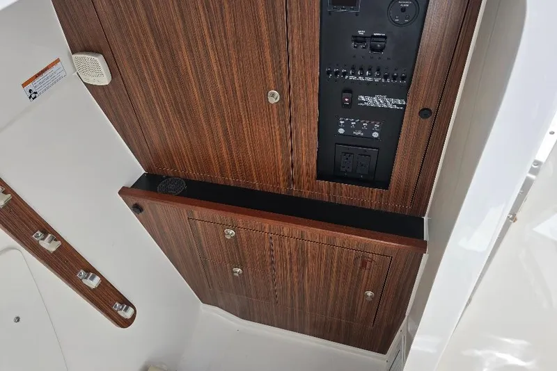 Slide: The Image of 2024 Pursuit DC 326 Dual Console interior with wood paneling and control panel. - 26