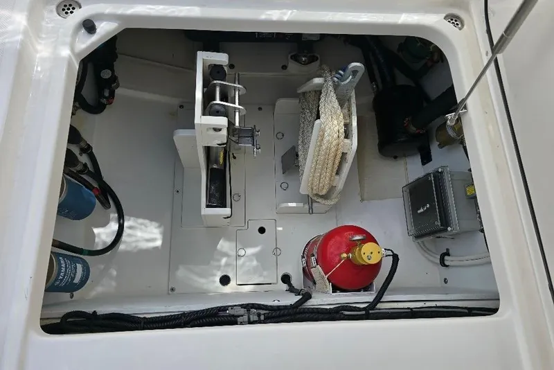 Slide: The Image of 2024 Pursuit DC 326 Dual Console storage compartment with equipment and fire extinguisher. - 28