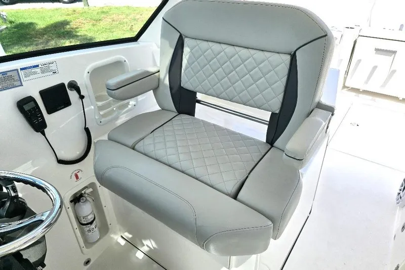Slide: The Image of 2024 Pursuit DC 326 Dual Console boat seat with quilted upholstery and armrest. - 6
