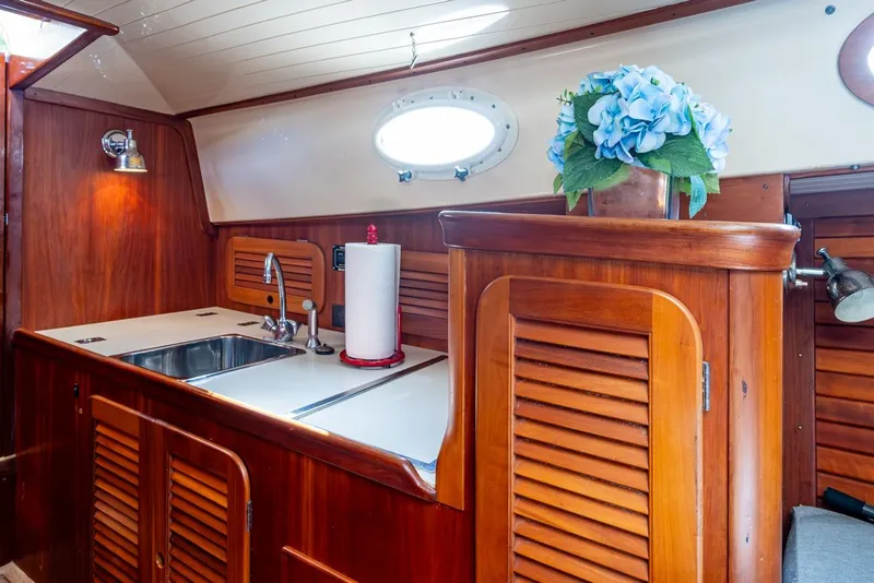 Slide: The Image of 2001 Hinckley Picnic Boat Classic interior with wooden cabinetry and sink. - 13