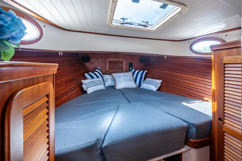 Slide: The Image of Cozy cabin interior of 2001 Hinckley Picnic Boat Classic with wood paneling and cushions. - 14