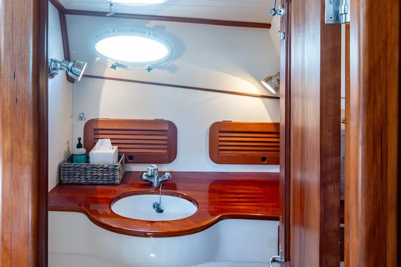 Slide: The Image of 2001 Hinckley Picnic Boat Classic bathroom with wooden cabinetry and modern fixtures. - 16