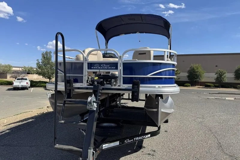 Slide: The Image of 2017 Sun Tracker FISHIN' BARGE® 20 DLX pontoon boat on trailer in parking lot. - 13