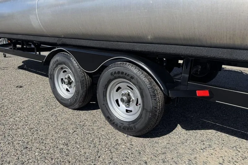 Slide: The Image of 2017 Sun Tracker FISHIN' BARGE® 20 DLX trailer wheels on asphalt road. - 16