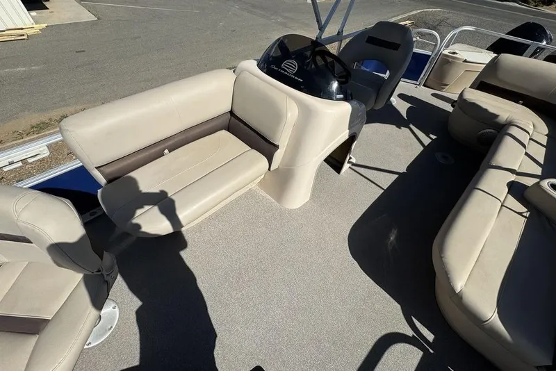 Slide: The Image of 2017 Sun Tracker FISHIN' BARGE® 20 DLX interior with beige seating and steering console. - 21