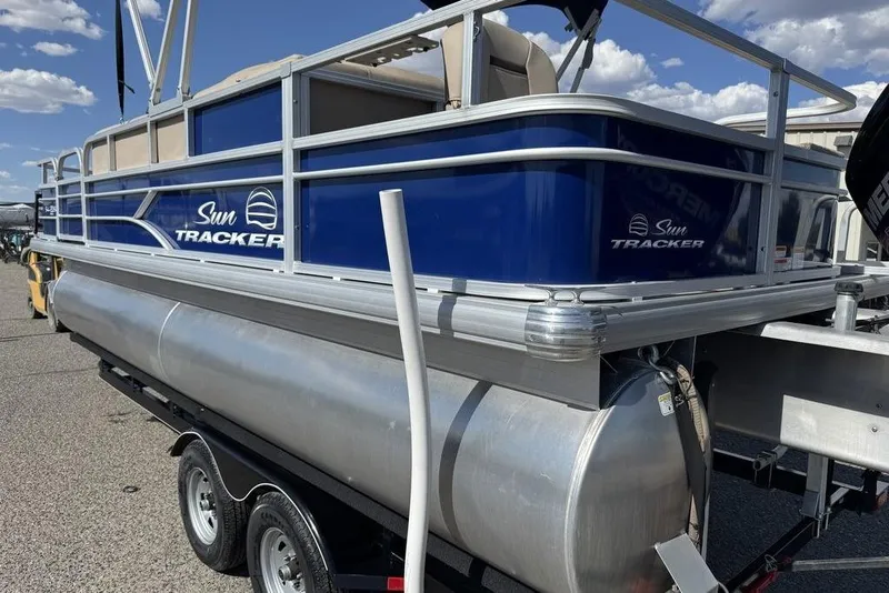Slide: The Image of 2017 Sun Tracker FISHIN' BARGE® 20 DLX pontoon boat on trailer, blue and silver design. - 3