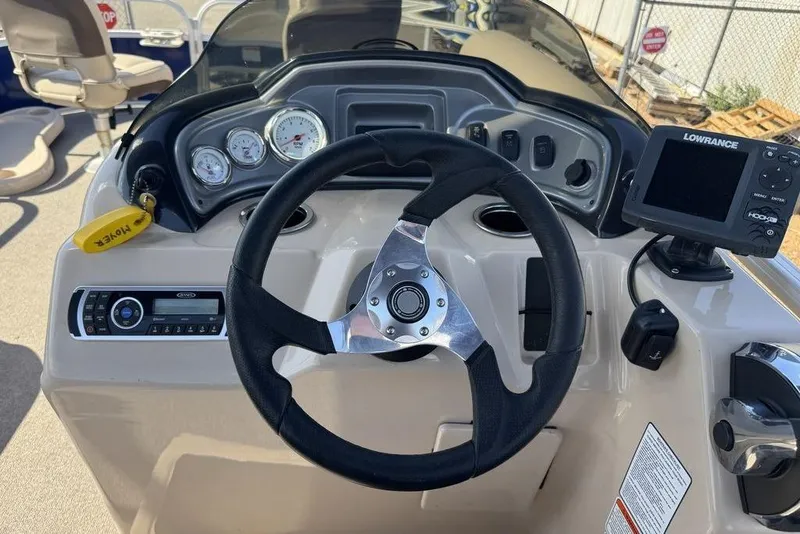 Slide: The Image of 2017 Sun Tracker FISHIN' BARGE® 20 DLX dashboard with steering wheel and Lowrance fishfinder. - 46