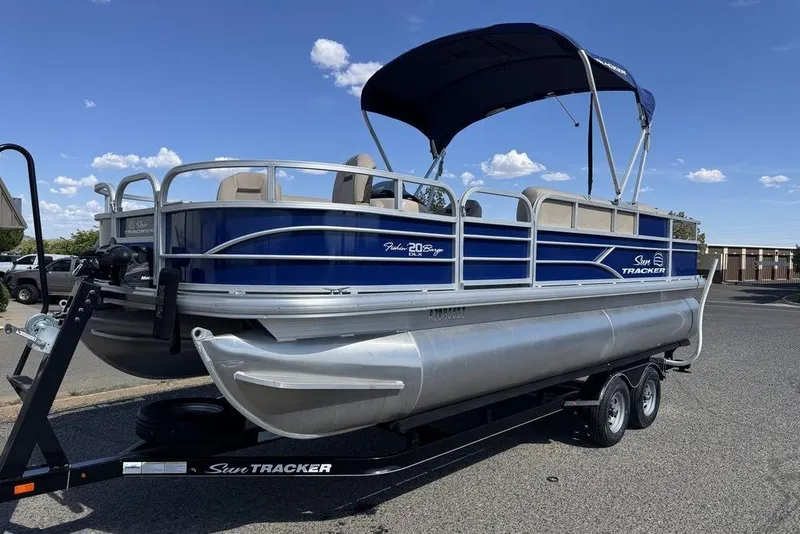 Slide: The Image of 2017 Sun Tracker FISHIN' BARGE® 20 DLX pontoon boat on trailer, blue and silver design. - 5