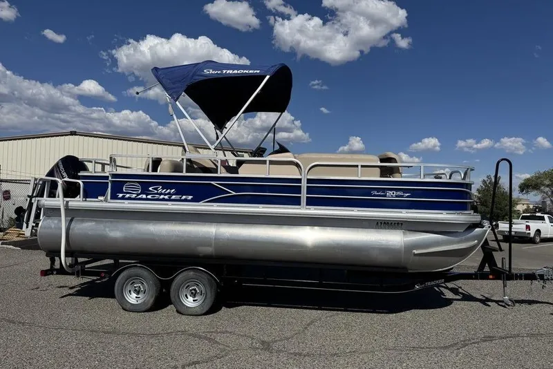 Slide: The Image of 2017 Sun Tracker FISHIN' BARGE® 20 DLX pontoon boat on trailer, blue and silver design. - 50