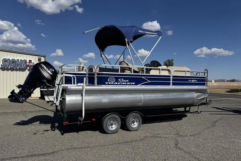 Slide: The Image of 2017 Sun Tracker FISHIN' BARGE® 20 DLX pontoon boat on trailer, parked outdoors. - 52